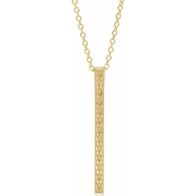Close up of yellow gold detailed bar necklace